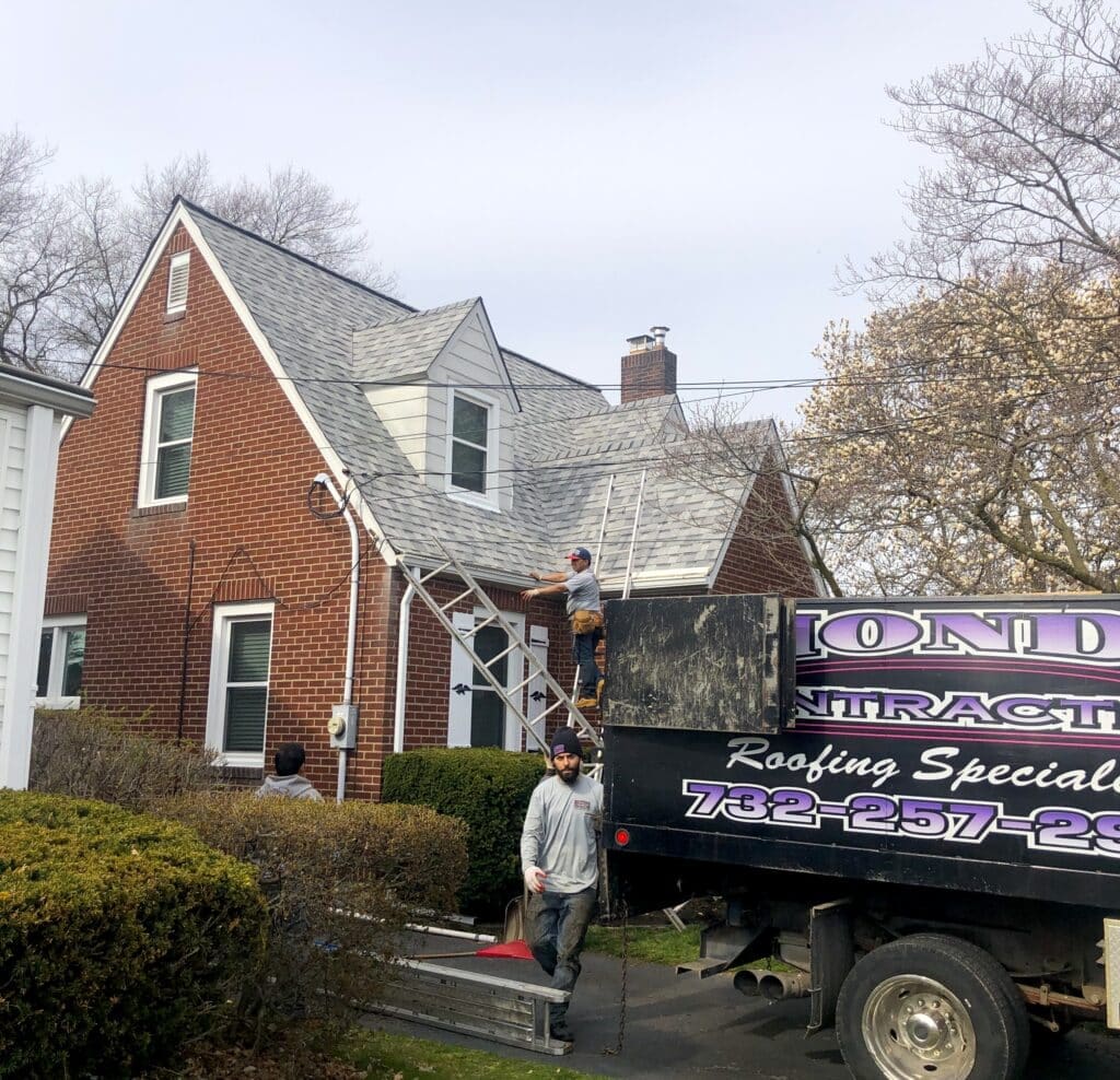 Emergency East Brunswick Roof Repair a Man Standing Next to a Truck in Front of a House East Brunswick Roof Repair