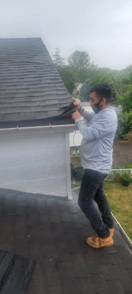 Arranging for a Pre fall Nj Roofing Inspection a Man Standing on Top of a Roof Checking Roof Shingles Arrange for a Nj Roofing Inspection