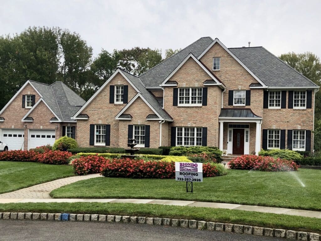 Grand Manor Luxury Roofing Shingles Installation a Purple Letter B in Front of a Green Background