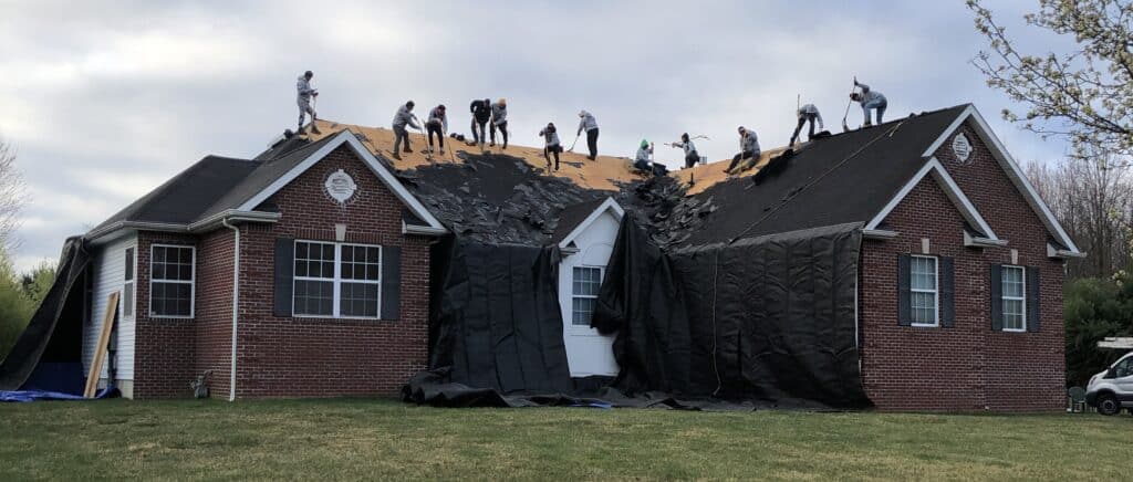 Inspired Nj Roofers Setting the Bar High Workers on a Roof Working on a Red Brick House